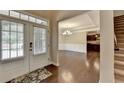 Welcoming entryway with gleaming hardwood floors leading to a dining area, kitchen, and staircase at 4395 Wildbrooke Pkwy, Cumming, GA 30041