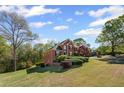 Beautiful two-story brick home set on a lush green lawn with mature trees and manicured landscaping at 4631 Crooked Creek Ln, Villa Rica, GA 30180