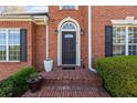 Close-up of the brick-surrounded front door and porch, including potted plants at 4631 Crooked Creek Ln, Villa Rica, GA 30180