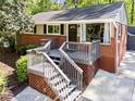 Quaint home featuring a brick exterior, charming front porch, and manicured landscaping for curb appeal at 1211 Argonne Ne Way, Atlanta, GA 30324