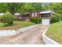 Inviting brick home showcasing an attached garage and a long driveway at 1766 Sw Brewer Sw Blvd, Atlanta, GA 30310
