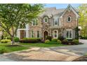 Beautiful stone and brick home with a brick paver driveway and lush landscaping at 3215 Oxleas Ct, Cumming, GA 30041