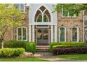Elegant front entrance featuring arched double doors and manicured landscaping at 3215 Oxleas Ct, Cumming, GA 30041