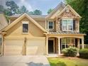 Inviting two-story home featuring a stone facade, a two-car garage, and well-manicured landscaping at 365 Friars Head Dr, Suwanee, GA 30024