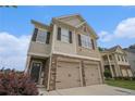 Charming two-story home featuring a two-car garage and stone accents under a bright blue sky at 4044 Elsdon Dr, Austell, GA 30106