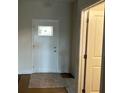 Entryway with a white front door with inset window and a light-colored rug on dark floors at 3536 Dogwood Pass, Stonecrest, GA 30038