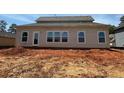 Rear exterior view of home with large windows and door, ready for finishing at 3536 Dogwood Pass, Stonecrest, GA 30038
