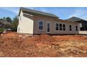 Side and rear exterior view of home with large windows and door, ready for finishing at 3536 Dogwood Pass, Stonecrest, GA 30038