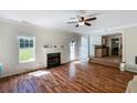 Bright living room featuring hardwood floors, a fireplace, and a ceiling fan at 6955 Pompas Ct, Douglasville, GA 30135