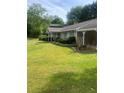 Single-story home with a covered carport, neat landscaping, and a well-maintained lawn and mature trees at 4184 Red Laurel Way, Snellville, GA 30039