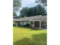 Single-story home with a covered carport, neat landscaping, and a well-maintained lawn and mature trees at 4184 Red Laurel Way, Snellville, GA 30039