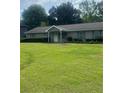 Charming single-story home featuring a well-manicured lawn, complemented by mature trees and neatly trimmed hedges at 4184 Red Laurel Way, Snellville, GA 30039