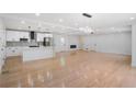 Bright living room with wood floors, recessed lighting, and a kitchen featuring modern appliances at 4307 Cedar Wood Sw Dr, Lilburn, GA 30047