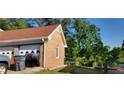 Garage with a brick exterior, white trim, and two car doors, offering ample space for parking at 4662 Burns Rd, Lilburn, GA 30047