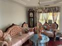 Features ornate pink sofas, a vintage clock, and unique decor, creating a distinctive and furnished living space at 5001 Panola Mill Dr, Lithonia, GA 30038