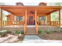 Inviting covered porch with a swing and rocking chairs, perfect for relaxing outdoors at 2435 Farmer Road, Conyers, GA 30012