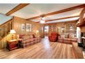 Cozy living room featuring wood paneling, wood beam ceiling, and a brick fireplace at 2435 Farmer Road, Conyers, GA 30012