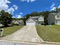 Inviting two-story home with a spacious driveway, lush lawn, and mature trees creating a serene setting at 1421 Isleworth Cir, College Park, GA 30349