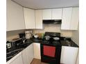 Functional kitchen with white cabinets, black countertop, and essential appliances for everyday cooking at 1421 Isleworth Cir, College Park, GA 30349