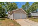 Attached two-car garage with driveway and well-maintained lawn and landscaping at 1363 To Lani Farm Rd, Stone Mountain, GA 30083