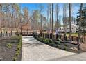 Long brick driveway leading to a black gated fence and beautiful white home at 1455 Rucker Cir, Woodstock, GA 30188