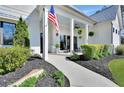 Inviting front porch with rocking chairs, lush greenery, and American flag at 1455 Rucker Cir, Woodstock, GA 30188