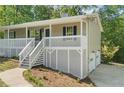 Charming home featuring a covered porch, white railings, and a freshly landscaped yard at 201 Rustin Dr, Dallas, GA 30157