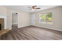 Bright living room with wood laminate flooring, a ceiling fan, and ample natural light at 201 Rustin Dr, Dallas, GA 30157