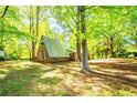 Unique A-frame cabin nestled among mature trees on a verdant lawn at 1098 Cown Rd, Villa Rica, GA 30180