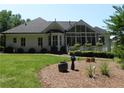 Backyard featuring lush green grass, mature landscaping, a deck and a sunroom with lots of light at 4019 Hickory Fairway Dr, Woodstock, GA 30188