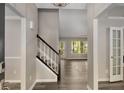 Welcoming entryway with dark floors, staircase, and abundant natural light at 1200 Taylor Oaks Dr, Roswell, GA 30076
