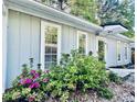 Quaint single-story home with gray siding and white trim, surrounded by lush greenery at 4437 Janice Dr, Snellville, GA 30039