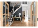 Elegant foyer with hardwood floors, staircase with iron spindles and decorative paneled wall at 3984 Earney Rd, Woodstock, GA 30188