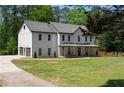 Stunning two-story white home featuring an attached three car garage and inviting front porch at 3984 Earney Rd, Woodstock, GA 30188