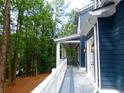 The spacious covered porch features white columns, ceiling fans and provides a view of the wooded yard at 4101 Brookview Se Dr, Atlanta, GA 30339
