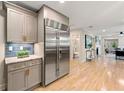 Modern kitchen with stainless steel refrigerator, marble countertops and hardwood flooring throughout at 1186 Thomas Rd, Decatur, GA 30030