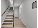Inviting hallway featuring a staircase with wood railings and elegant wood-look floors, creating a warm ambiance at 3677 Sorrel Ln, Duluth, GA 30096