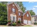 Beautiful brick home with a manicured lawn, two car garage, and mature trees at 3215 Rose Petal Ln, Powder Springs, GA 30127