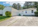 A white, one-story home featuring an attached garage and a long driveway at 2058 Corners Cir, Lithonia, GA 30058
