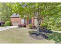 Traditional brick home with lush landscaping, mature tree and an inviting curb appeal at 1641 Rocky Knoll Ln, Dacula, GA 30019