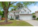 Inviting traditional two-story home featuring a well-maintained lawn, two-car garage, and a charming blue front door at 2263 Seatton Ct, Marietta, GA 30062