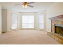 Living room with stone fireplace, ceiling fan, and carpeted floors at 1166 Memory Ln, Lawrenceville, GA 30044