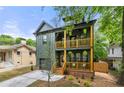 Olive green two-story home featuring double stacked wood porches and lush landscaping at 224 Cambridge Ave, Decatur, GA 30030