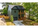 Olive-green home with a modern design, a well-manicured lawn and double stacked wood-railed porches at 224 Cambridge Ave, Decatur, GA 30030