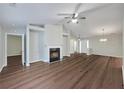 Open living room with a fireplace, hardwood floors, and a ceiling fan at 2416 Centennial Hill Nw Way, Acworth, GA 30102
