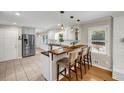 Bright kitchen with white cabinets, stainless steel appliances, and a breakfast bar with seating at 2396 Midvale Cir, Tucker, GA 30084