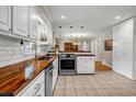 Updated kitchen featuring white subway tile backsplash, wood countertops, and stainless steel appliances at 2396 Midvale Cir, Tucker, GA 30084