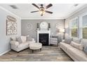 Cozy living room with a fireplace, neutral decor, and plenty of natural light at 4440 Spring Mtn Ln, Powder Springs, GA 30127