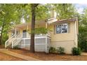 Inviting yellow home featuring a quaint front porch, side stairs and complemented by natural surroundings at 21 Misty Hollow Ct, Euharlee, GA 30145
