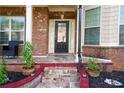 Close-up of brick-paved front porch with decorative columns and lush landscaping detail at 3770 Falling Leaf Ln, Cumming, GA 30041